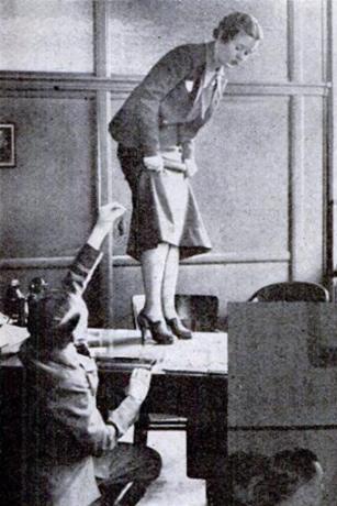 Telegraph boy catches mouse while lady standing on table watches