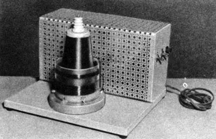 Fully assembled Tesla coil with perforated metal cover.