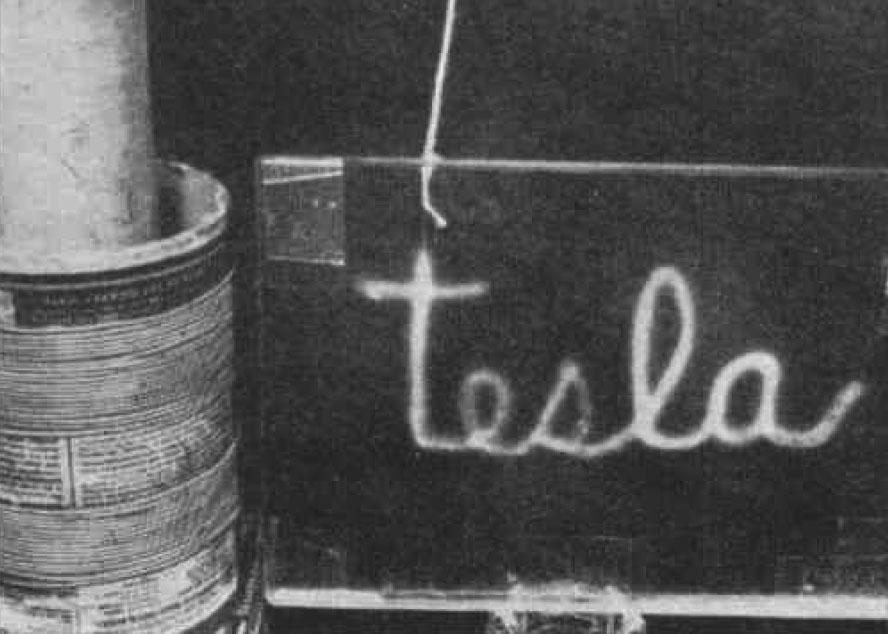 The word TESLA illuminated by high-frequency alternating current.