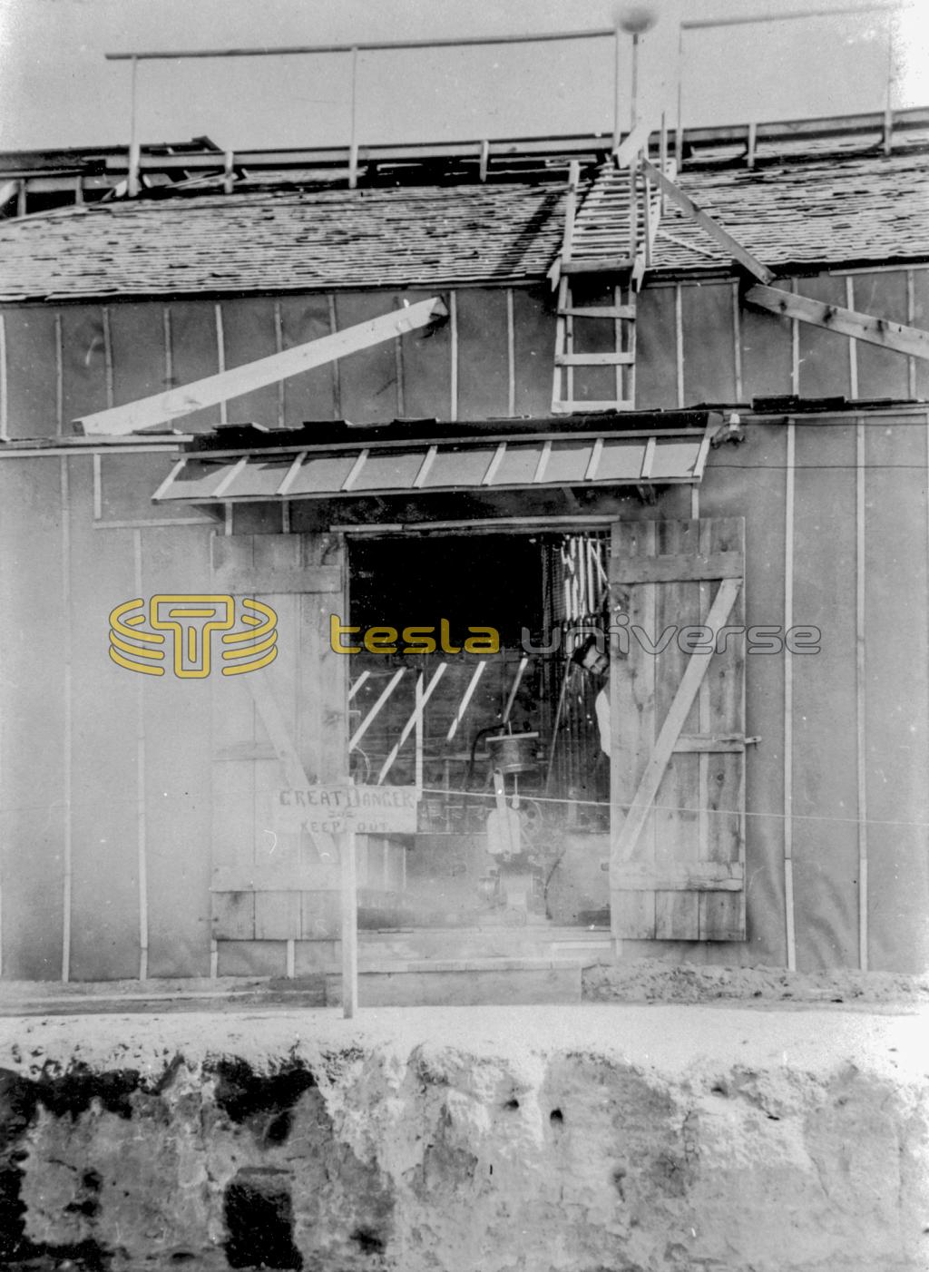 Tesla peeks out the door of the Colorado Springs laboratory, early summer 1899