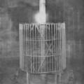 Tesla's Colorado Springs oscillator with bulb illuminated at top of extra coil