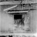 Tesla peeks out the door of the Colorado Springs laboratory, early summer 1899